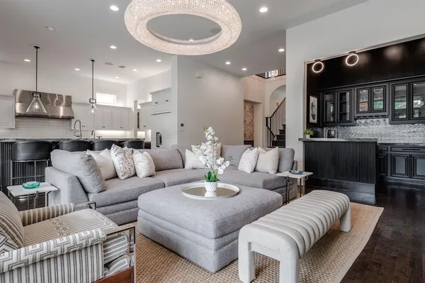 a living room with furniture kitchen and a chandelier