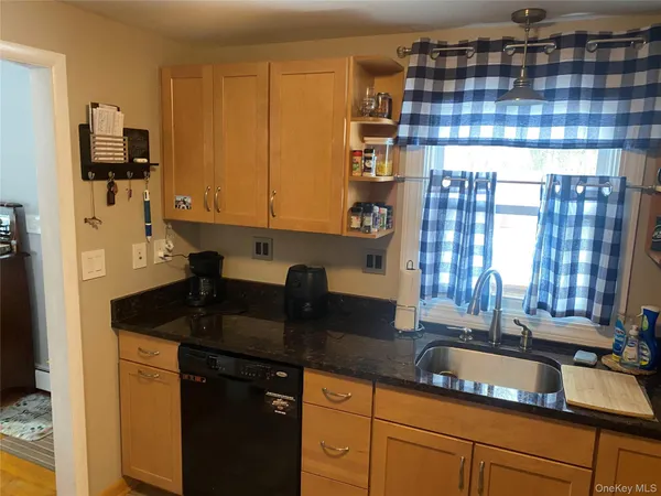 a kitchen with kitchen island granite countertop a sink a counter top space and cabinets