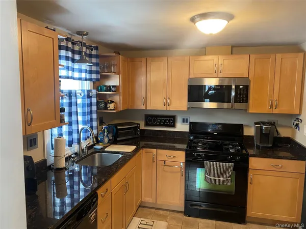a kitchen with stainless steel appliances granite countertop a stove and cabinets