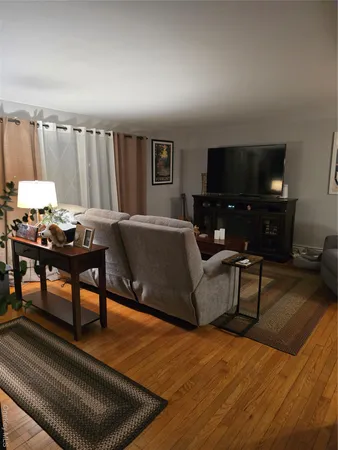 a living room with furniture a flat screen tv and a large window