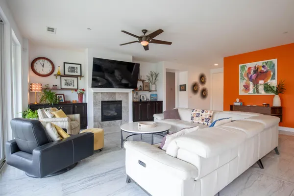 a living room with furniture a flat screen tv and a fireplace