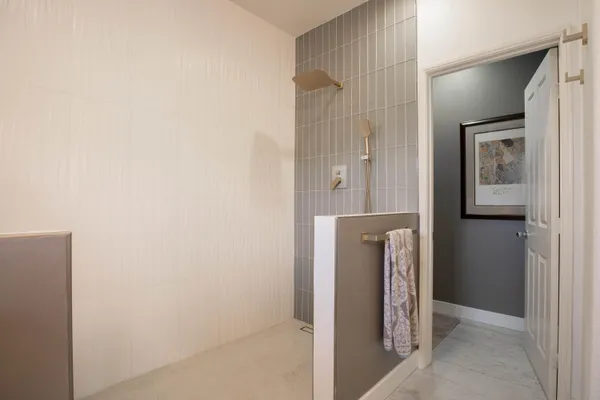 a view of hallway with bathroom and shower