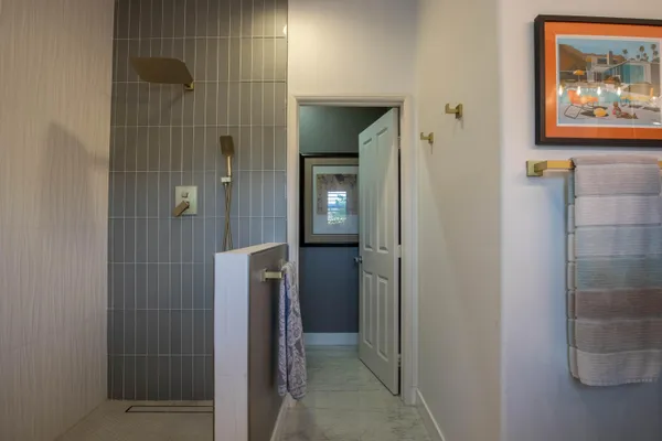 a bathroom with a painting on the wall and shower
