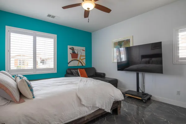 a bedroom with a bed a chandelier and a flat screen tv