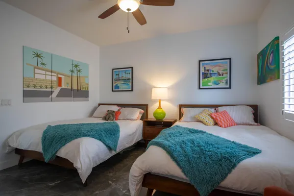 a bedroom with two beds and painting on the wall