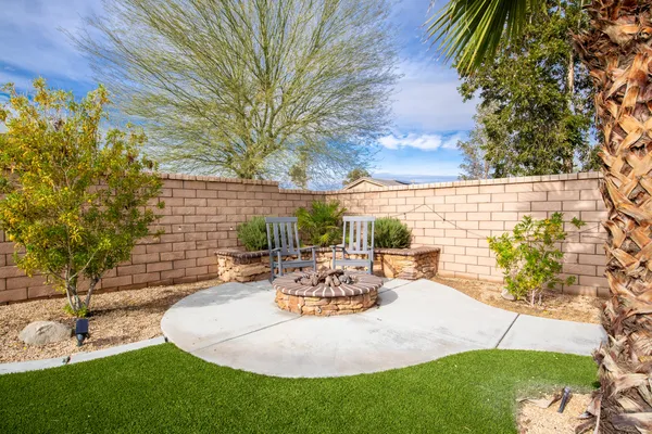 a view of a patio with table and chairs potted plants and large tree