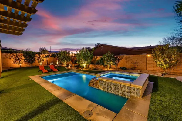 a view of a swimming pool with an outdoor seating a fireplace fire place and an outdoor space