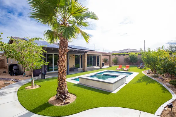 a view of a house with swimming pool and a yard