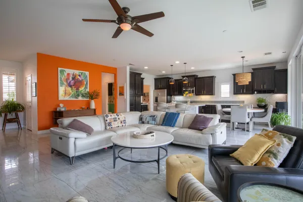 a living room with furniture kitchen view and a window