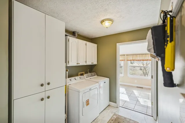 a utility room with cabinets washer and dryer