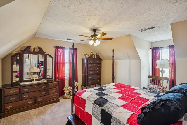 a bedroom with a bed a dresser and flat screen tv