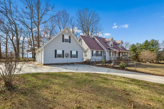 a front view of house with yard and trees in the background
