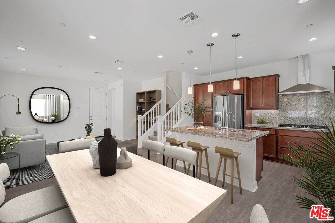 659 Daniel Freeman Circle Inglewood, CA 90301 - Photo 5 of 34 a kitchen with stainless steel appliances granite countertop a stove a sink a dining table and chairs