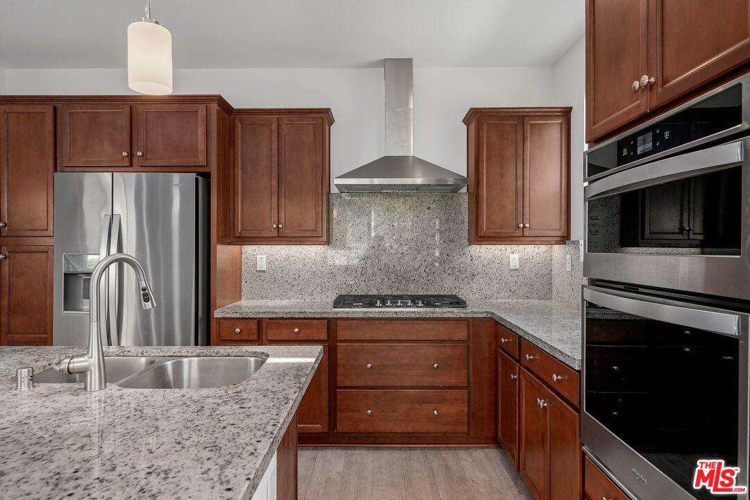 659 Daniel Freeman Circle Inglewood, CA 90301 - Photo 10 of 34 a kitchen with granite countertop wooden cabinets and stainless steel appliances