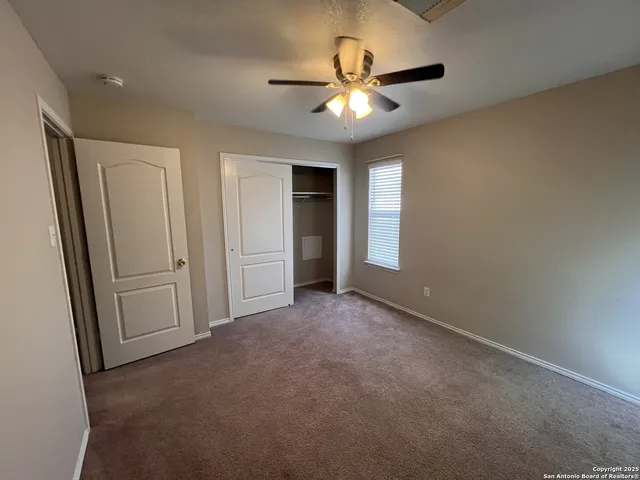 an empty room with chandelier fan