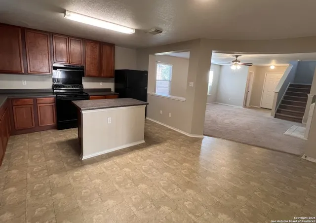 a large kitchen with stainless steel appliances granite countertop a stove a sink and a refrigerator