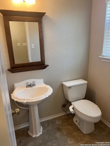 a white toilet sitting next to a bathroom sink