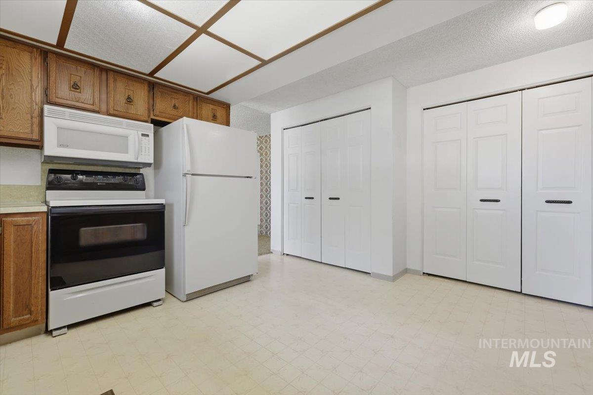 1311 North Middleton Road Nampa, ID 83651 - Photo 38 of 49 Kitchen area featuring wood cabinetry, white appliances including a refrigerator, range, and microwave