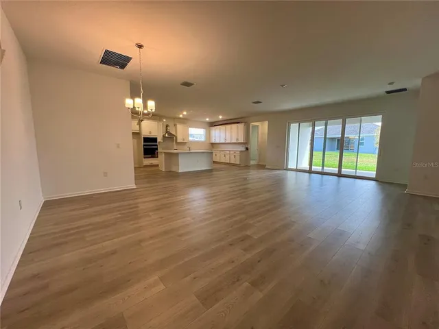 an empty room with wooden floor and fireplace