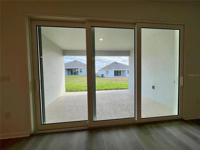 an empty room with wooden floor and glass door