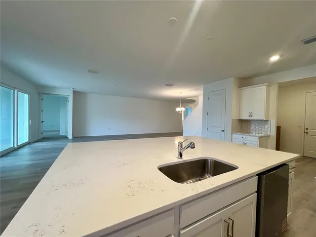 a kitchen with a sink and a stove top oven with wooden floor