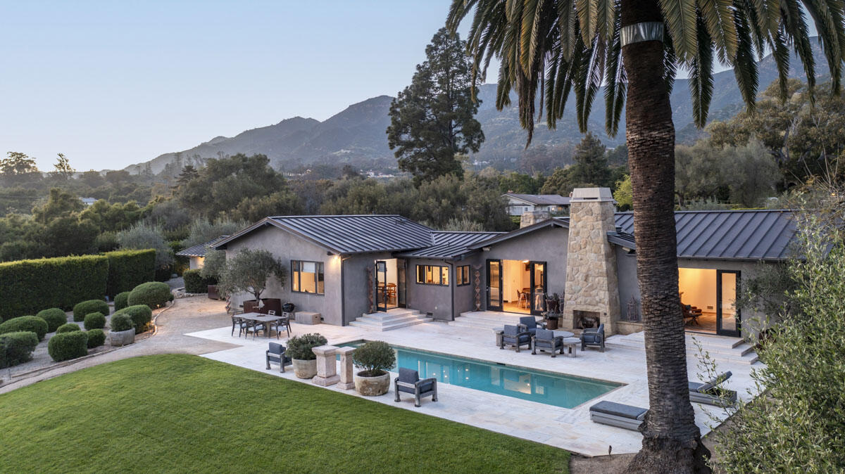 aerial view of a house with table and chairs under an umbrella