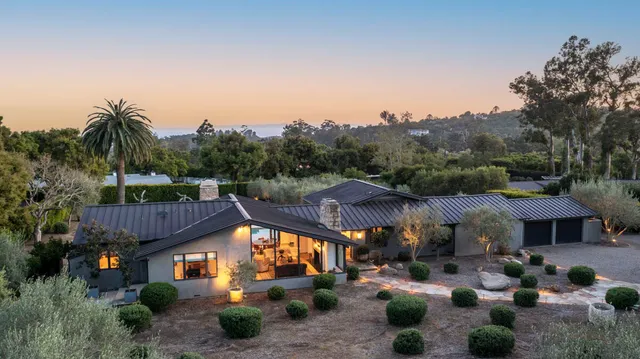 a view of a house with a patio table and chairs