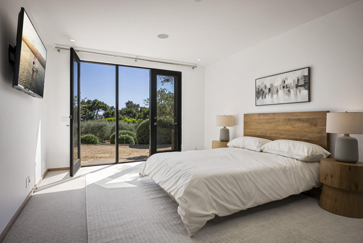 1190 Garden Lane Montecito, CA 93108 - Photo 27 of 43 a bedroom with a large bed and a flat tv screen