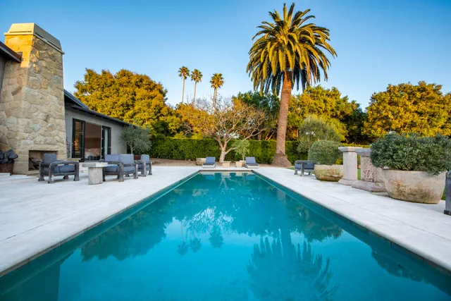a swimming pool with outdoor seating and yard