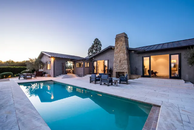 a view of a house with swimming pool and sitting area