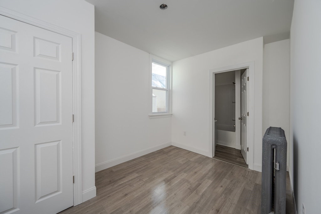 348 Walker Street Lowell, MA 01851 - Photo 17 of 20 an empty room with wooden floor and closet