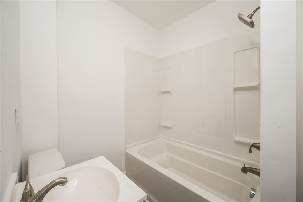 348 Walker Street Lowell, MA 01851 - Photo 20 of 20 a bathroom with a toilet and bathtub