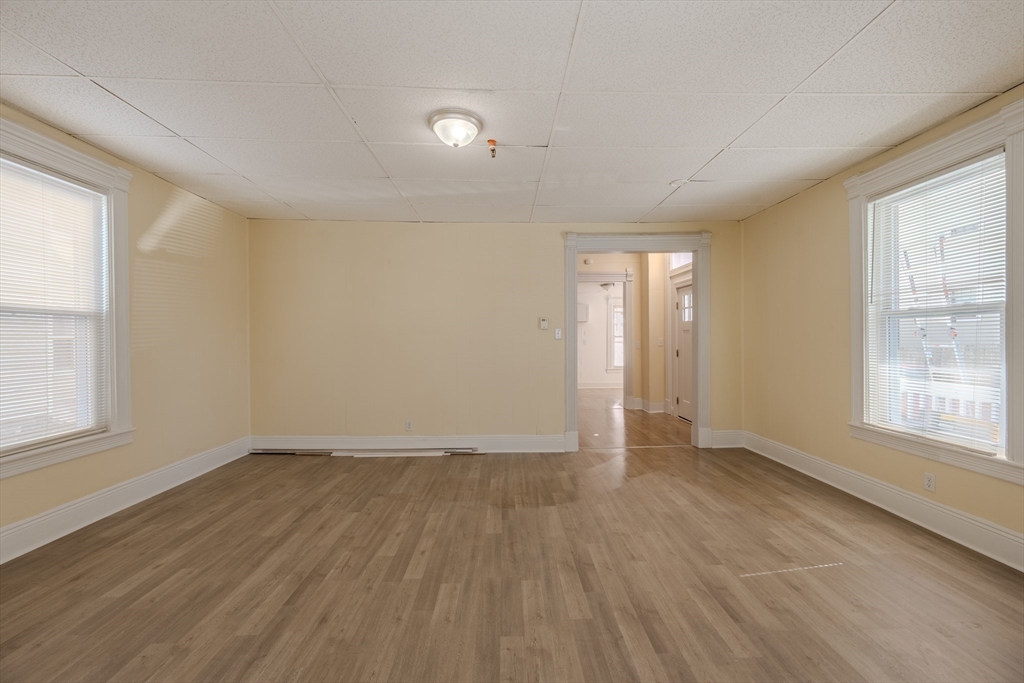 348 Walker Street Lowell, MA 01851 - Photo 4 of 20 an empty room with wooden floor and windows
