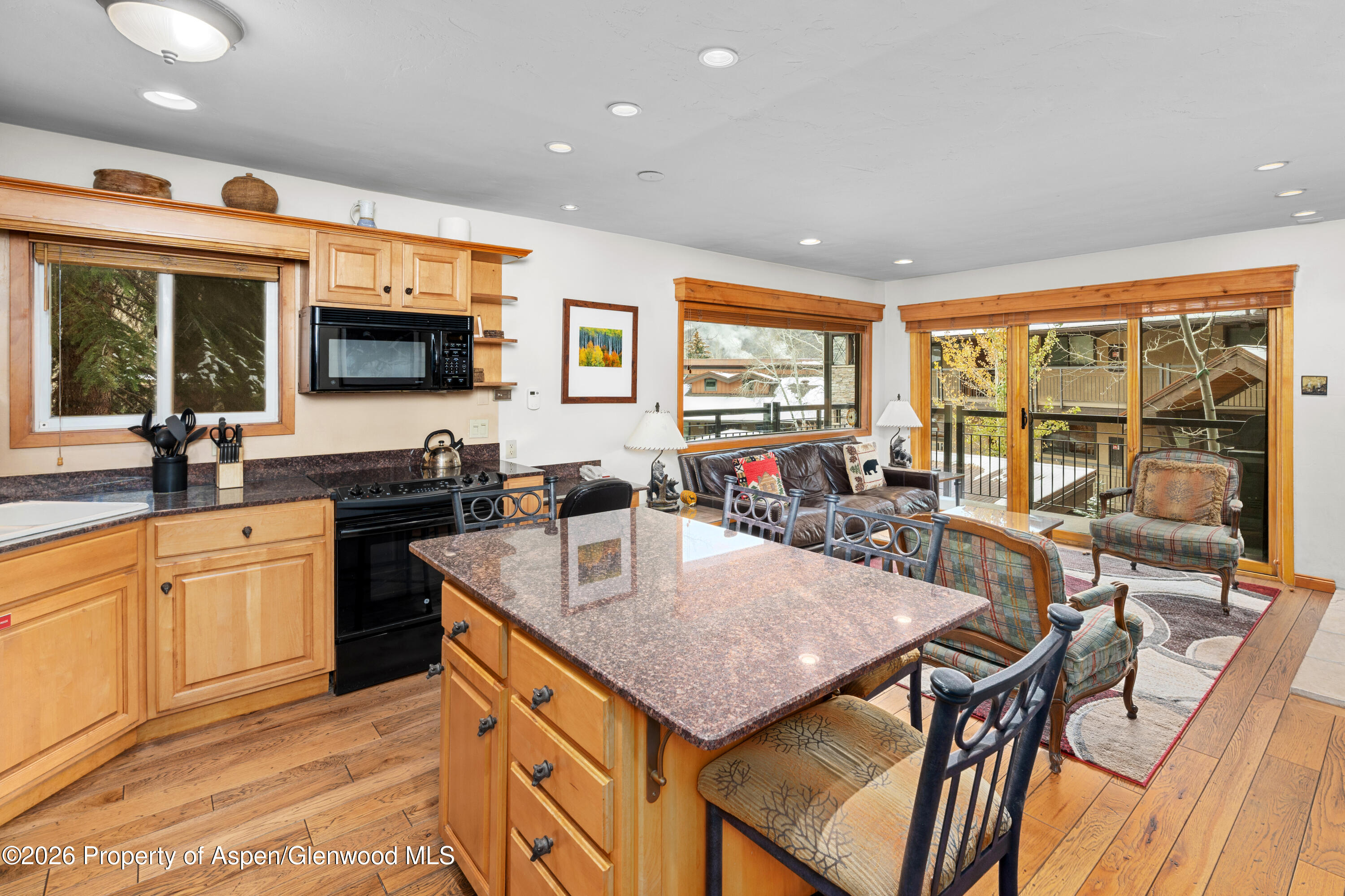 400 Wood Road, Unit 2111H Snowmass Village, CO 81615 - Photo 1 of 16 a kitchen with stainless steel appliances granite countertop a kitchen island a stove a table and chairs with wooden floor
