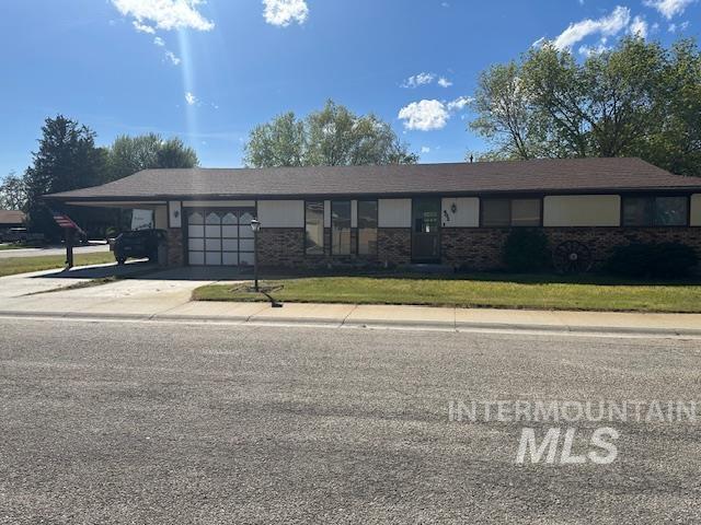 601 Riggs Avenue Emmett, ID 83617 - Photo 2 of 46 Single story home featuring a carport, driveway, brick siding, and a front lawn