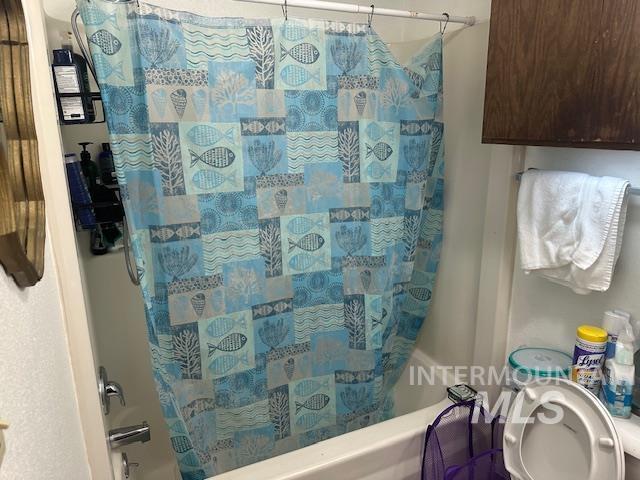 601 Riggs Avenue Emmett, ID 83617 - Photo 26 of 46 Bathroom featuring shower / bathtub combination with curtain and toilet