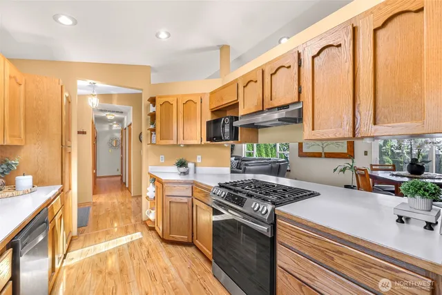 a kitchen with stainless steel appliances granite countertop a stove a sink and a refrigerator