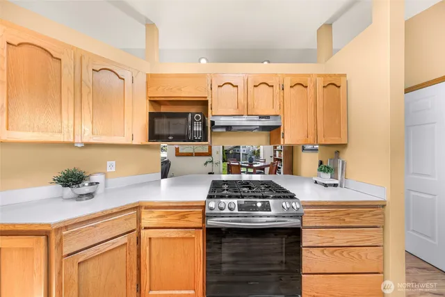 a kitchen with granite countertop a sink stove and cabinets