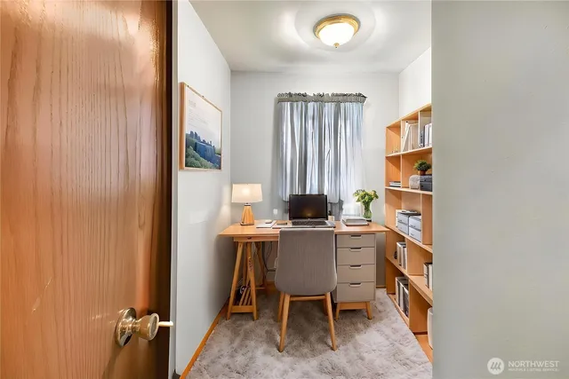 a view of a workspace with furniture and a window