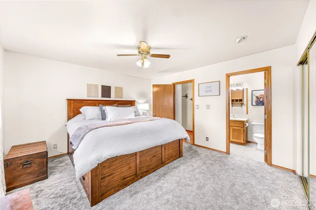 a bedroom with a large bed and ceiling fan