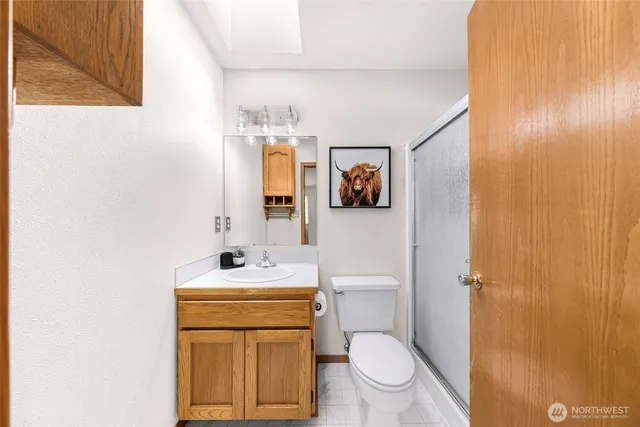 a bathroom with a granite countertop toilet sink and mirror