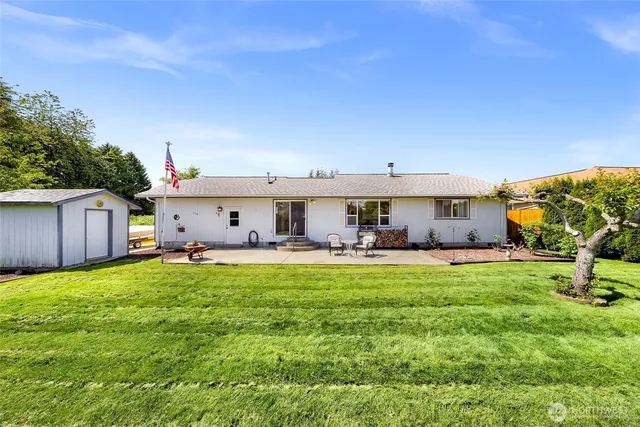 a view of a house with backyard and a tree