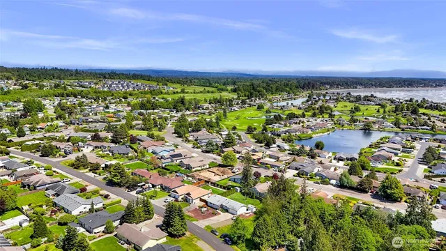 a view of an house with backyard and bushes