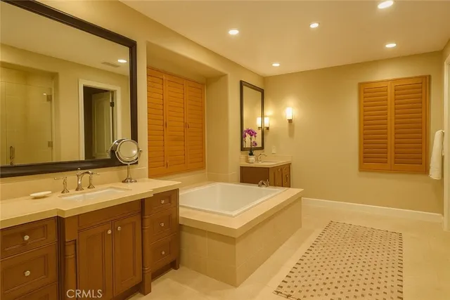 a bathroom with a tub sink and mirror