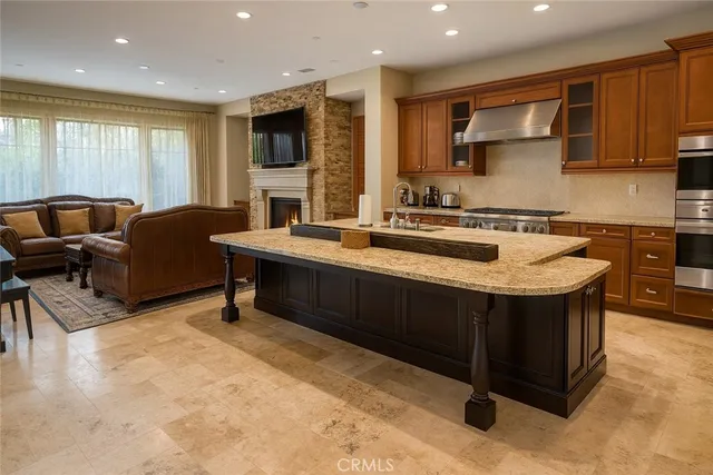 a kitchen with stainless steel appliances granite countertop a sink wooden cabinets and a granite counter tops