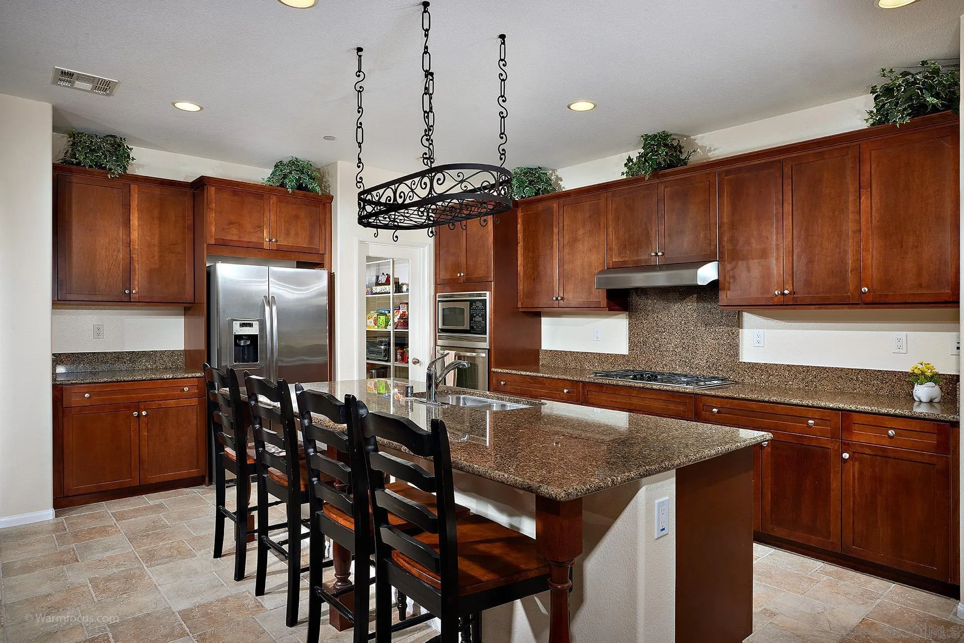 3025 Calico Street Santee, CA 92071 - Photo 13 of 59 a kitchen with stainless steel appliances granite countertop a kitchen island a table and chairs in it