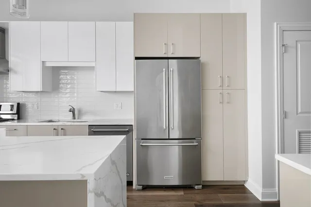 a kitchen with a refrigerator sink and cabinets