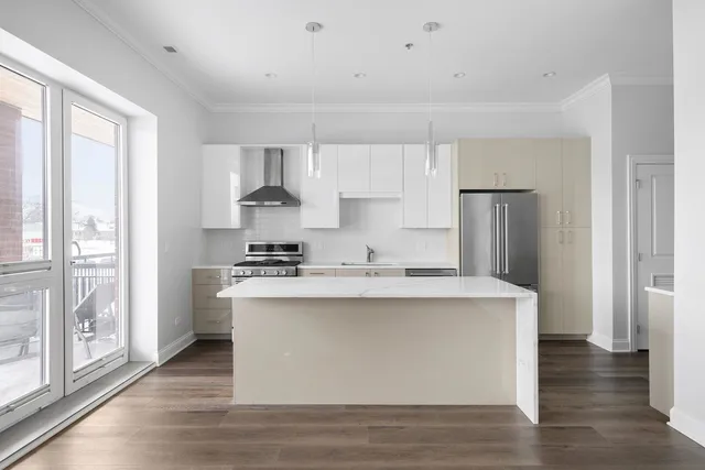 a view of kitchen with stainless steel appliances granite countertop a stove and a refrigerator