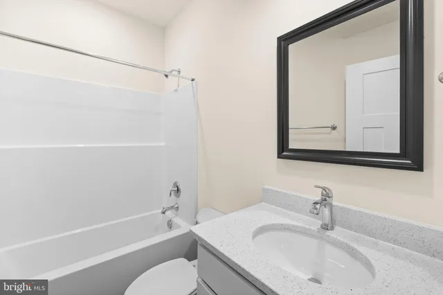 a bathroom with a sink vanity tub and shower