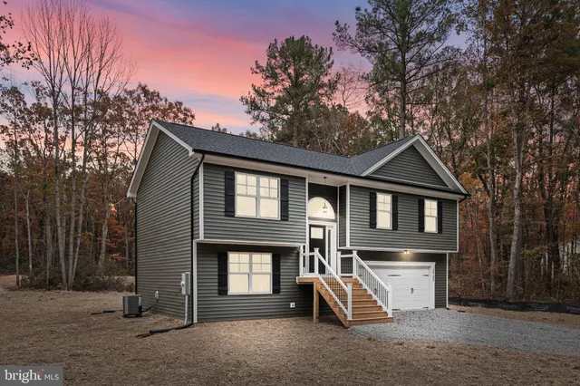 a view of a house with a yard and large tree